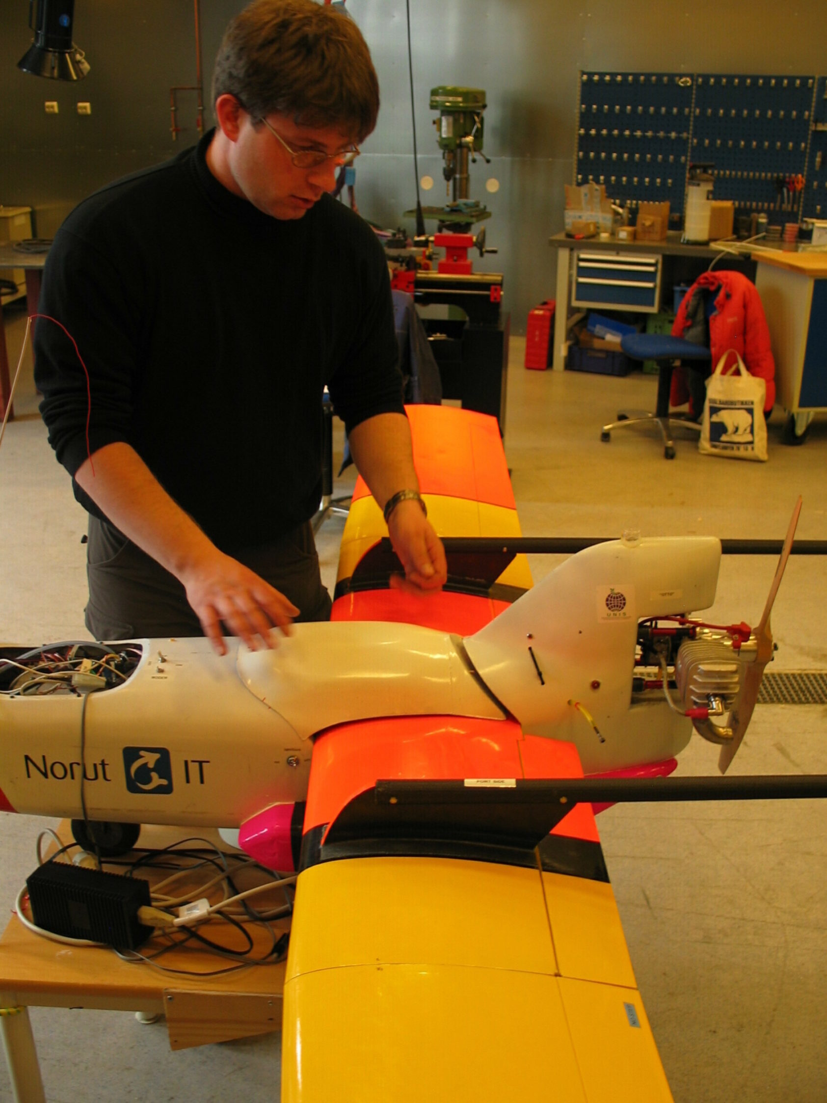 NORCE, Stian Solbø (Longyearbyen, 2006)., Drone uav 2006 stian solbø, , Mann jobber med en drone i et verksted.