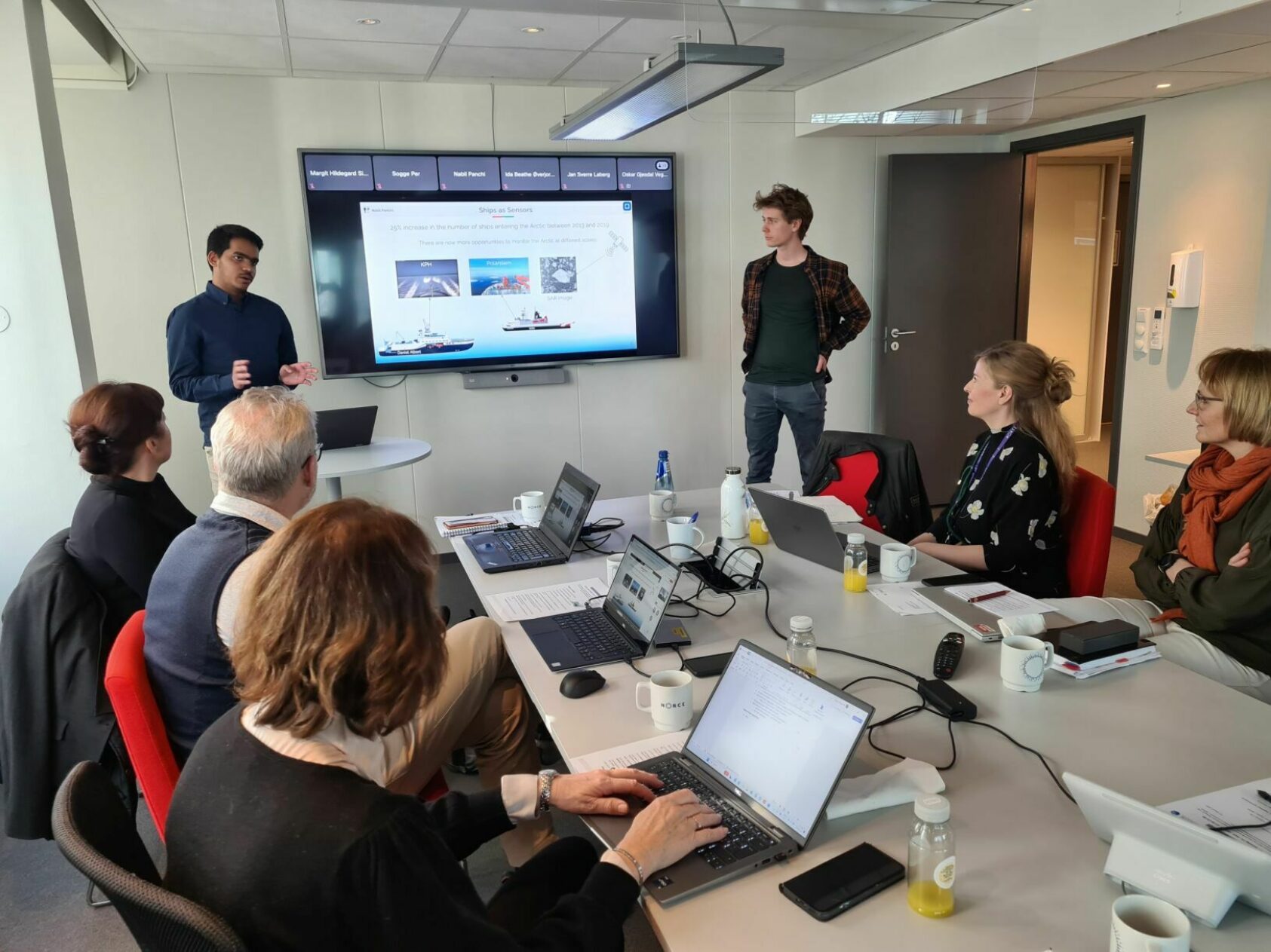 Daniel Albert, SINTEF, Resultatene fra forskningen som ble gjennomført på forrige tokt presenteres i Fiskeri- og Næringsdepartementet av PhD-kandidatene Nabil Panchi og Oskar Gjesdal Veggeland (NTNU). NORCE-forsker Margit Simon sitter forrest til høyre., Presenterer, <p>Foto: Daniel Albert, SINTEF</p>, 