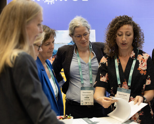 Thomas Hovmøller Ris, Avdelingsleder for Hav og miljø i NORCE Fiona Provan har vært initiativtaker for å få NORCE med som partner på Aqua Next, Stand2, <p>Thomas Hovmøller Ris, NORCE</p>, Seks personer rundet et lite bord studerer et hefte.