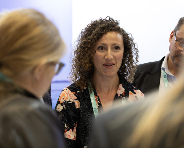 Thomas Hovmøller Ris, Forskningsgruppen Fiskebiologi og akvakultur har over 20 års erfaring innen forskning på fiskebiologi., Stand3, <p>Thomas Hovmøller Ris, NORCE</p>, Fokus på en som kvinne lytter interssert, omgitt av flere personer.