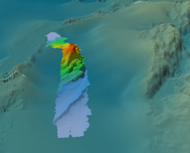 Illustrasjon: Nicki Riber Andreasen (GST)., Batymetrien avdekket en tidligere ukjent struktur som reiser seg 800 meter over den omkringliggende havbunnen, i linje med Gakkelryggen. Videre undersøkelser vil være nødvendig for å fastslå om den er knyttet til Gakkelryggen. De jevne områdene på bildet viser områder med lite eller ingen batymetriske data., Kart havbunn, , 