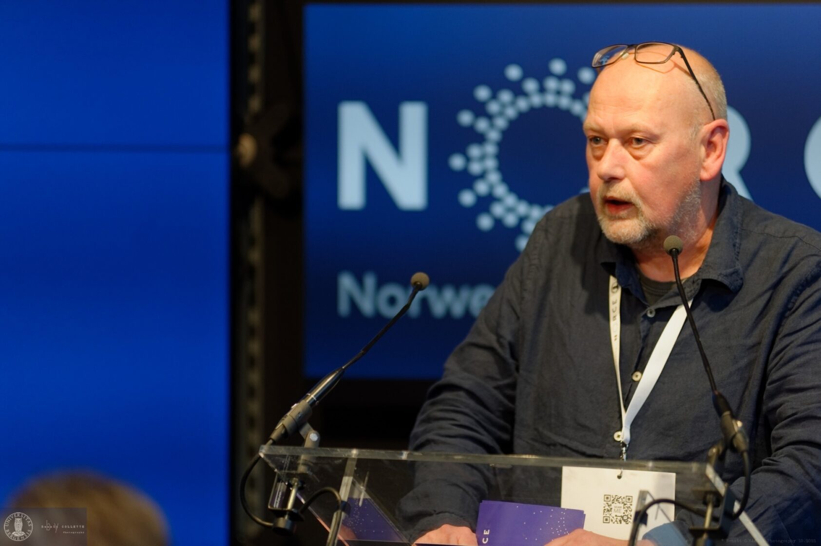 Foto: Benoit Collette, Trond Dokken, konserndirektør Klima og Miljø NORCE dro sammen med UiB-rektor Margaret Hagen gjennom behovene  for at forskningen må være åpen dersom vi skal klare å ta vare på kloden vår., 0777 6 BC 1324 by Benoît COLLETTE Photography v WEB 2560 px, <p>Benoît COLLETTE</p>, bilde av mann med NORCE-logo bak