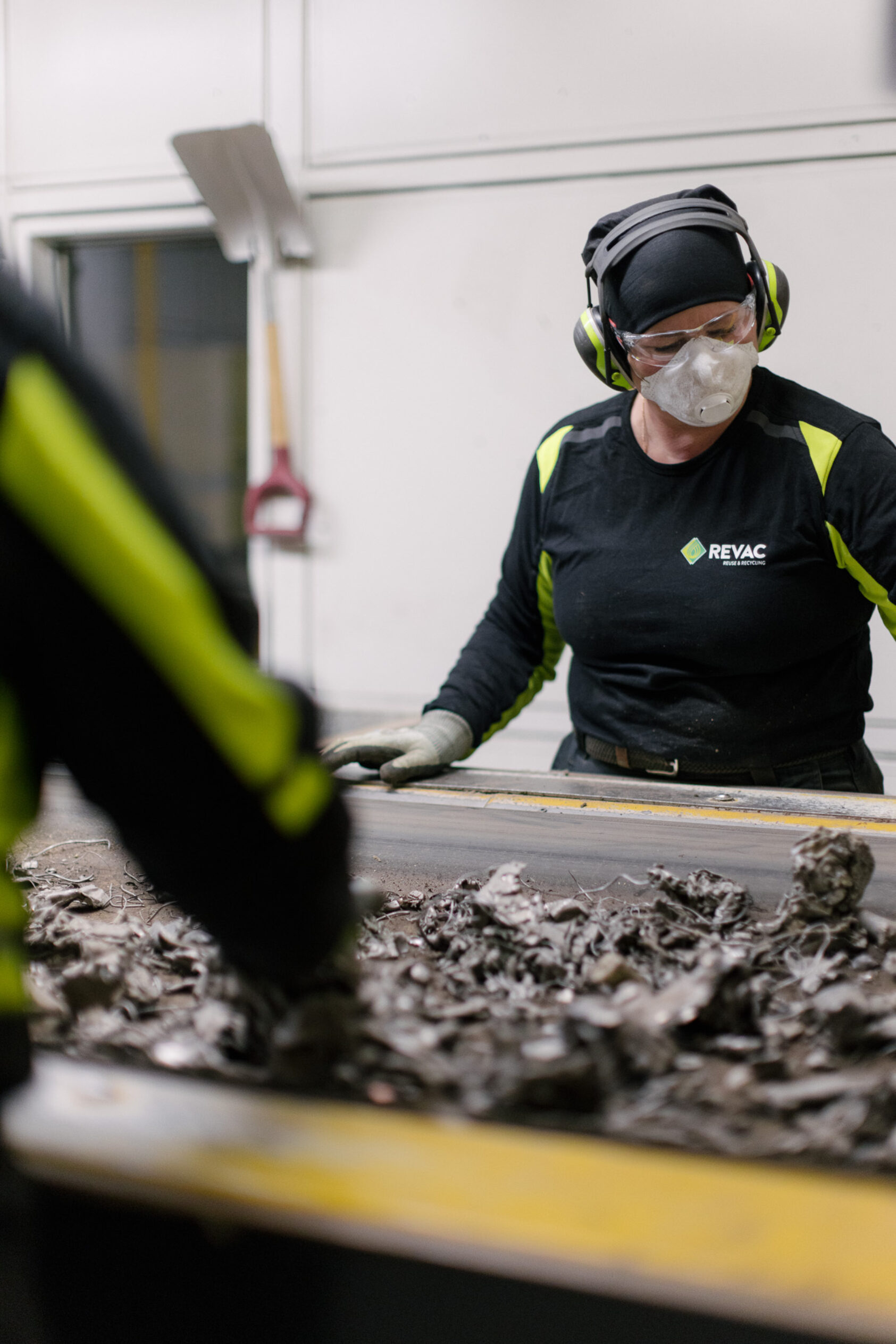 RENAS, I dag blir demontering og sortering i all hovedsak gjort manuelt. Dette må automatiseres., Manuelt arbeid på gjenvinningsstasjon, <p>RENAS</p>, To arbeidere sorterer avfall på et transportbånd.