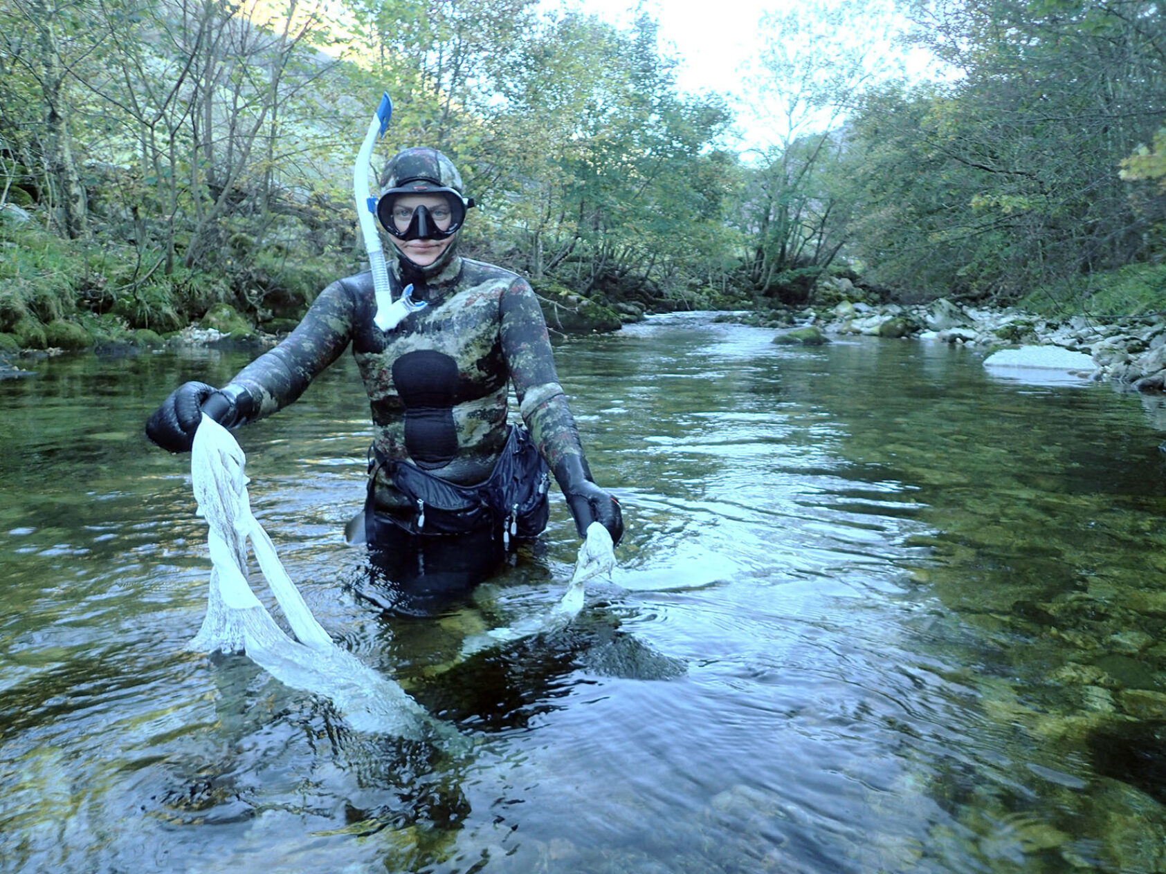 , NORCE-forsker Elisabeth Stöger i Omvikedalselven, Kvinnherad kommune i Vestland fylke, finner nok ett "traktoregg"- eller resten av en rundball som det ligger mye av i norske elver viser undersøkelsen fra NORCE LFI., PA060459 redusert, , NORCE-forsker Elisabeth Stöger i Omvikedalselven, Kvinnherad kommune i Vestland fylke, finner nok ett "traktoregg"- eller resten av en rundball som det ligger mye av i norske elver viser undersøkelsen fra NORCE LFI.