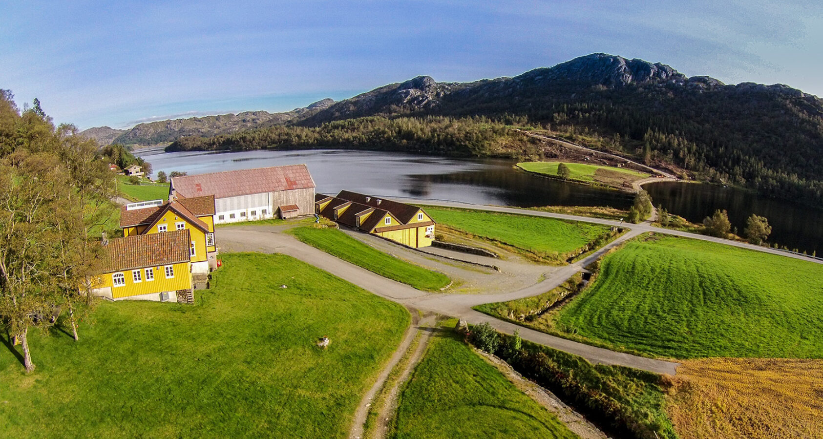 Nyyyt AS, GGEAS, Røysland Gård in Bjerkreim, Norway is one of four pilots in  HarvRESt., Picture 2, <p>Nyyyt AS, GGEAS</p>, Farm and farm fields, a lake in the background.
