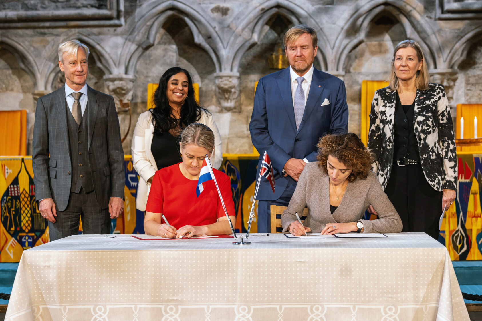 The Dutch Embassy in Oslo, Lubna Jaffery, Minister of Culture and Equality and His Majesty King Willem-Alexander of The Kingdom of The Netherlands is also seen in this picture., What, , wo people at a table, and four people standing behind them